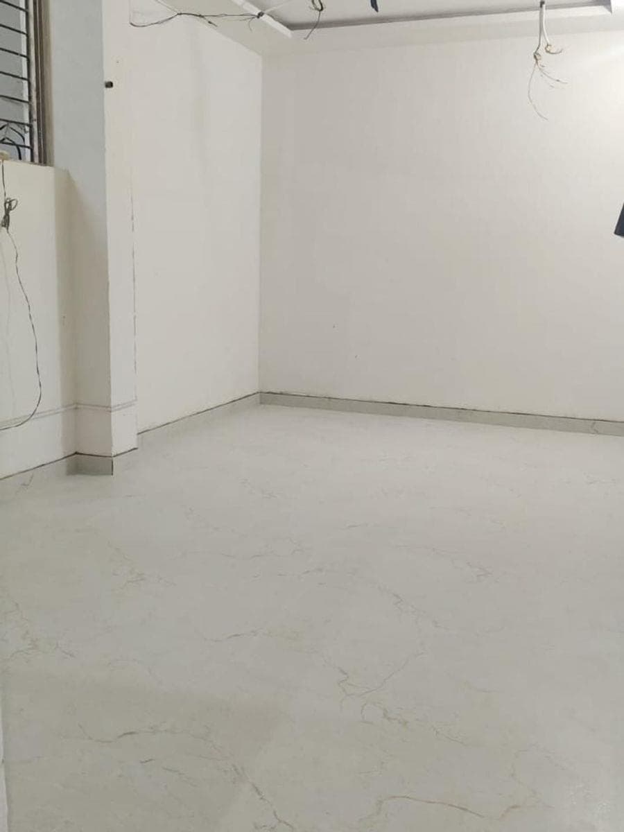 The room with new light marble-look floor tiles, white walls and wires ready for the lights